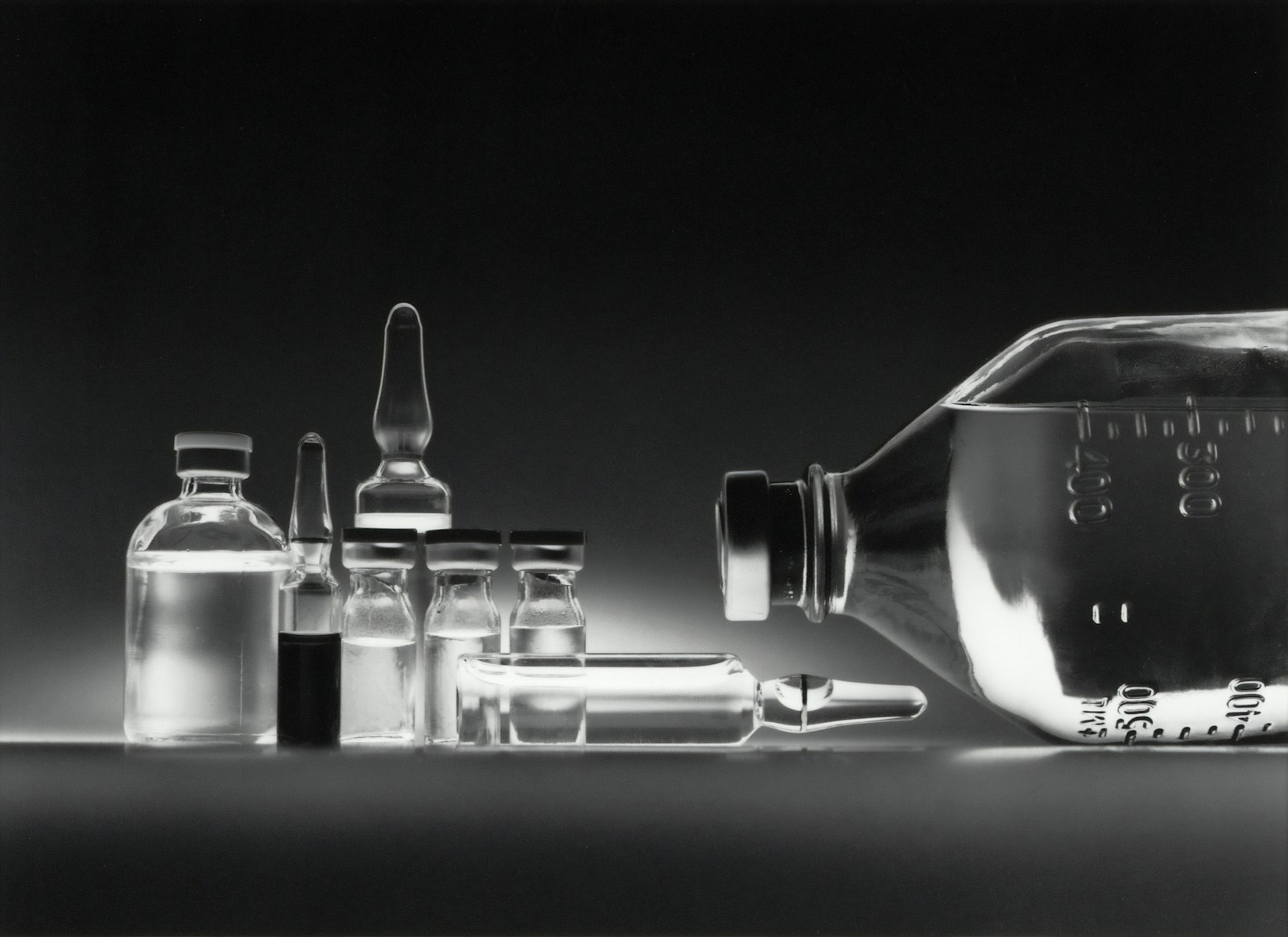 Pharmaceutical-grade glass vials on dark surface